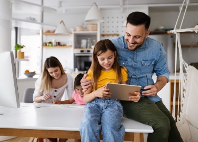 Family in a DIY room while working on projects and looking at their tablet