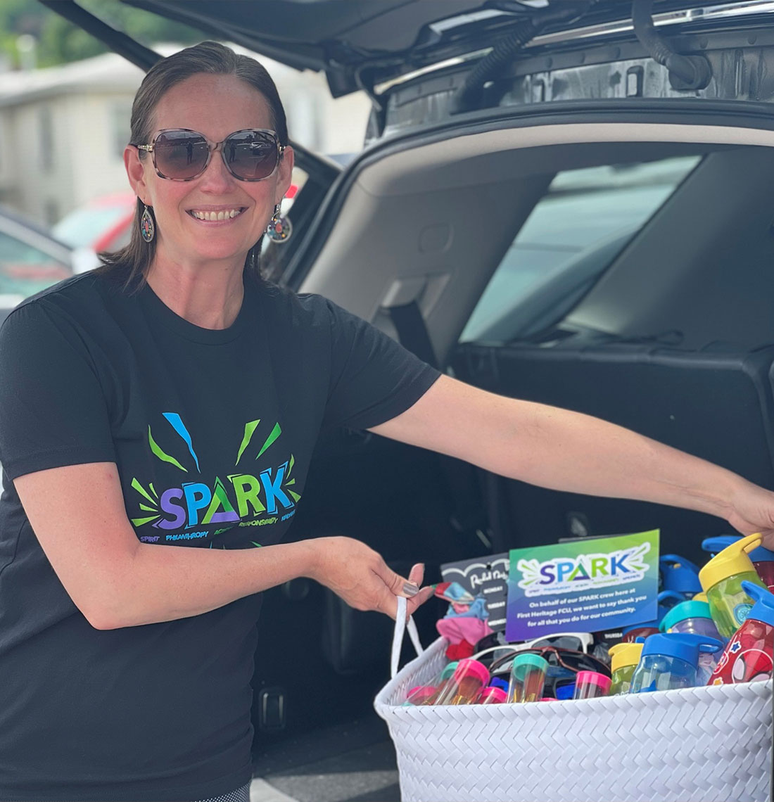 Woman wearing a SPARK shirt holding a basket of goodies