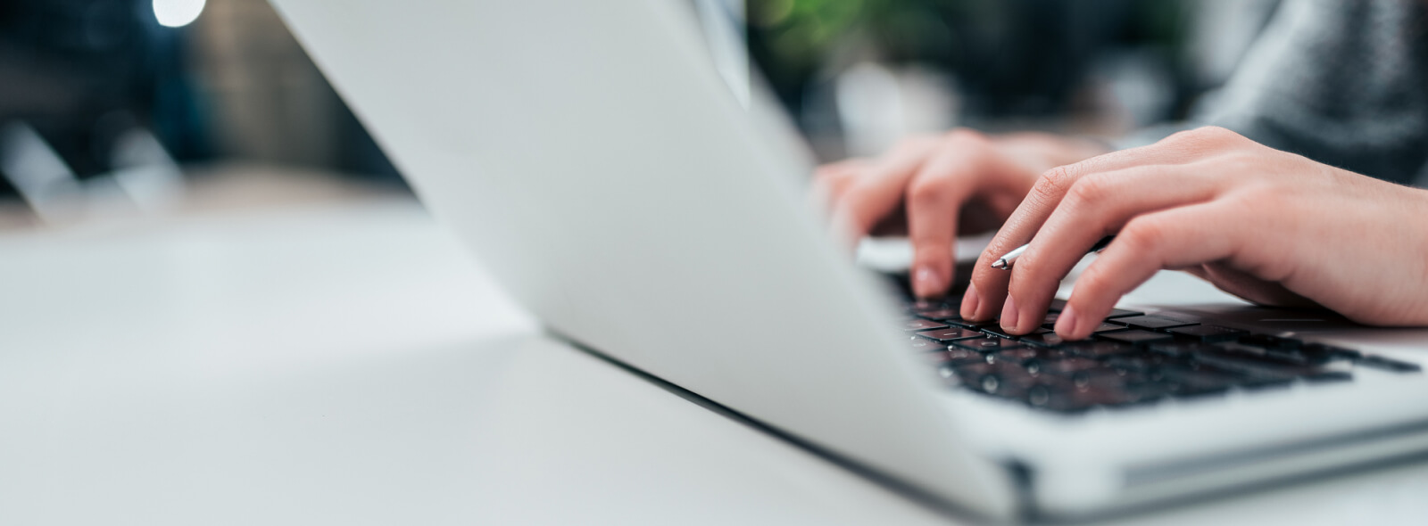 Hands typing on laptop