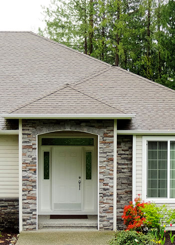 Photo of the front facade of a home with shrubby