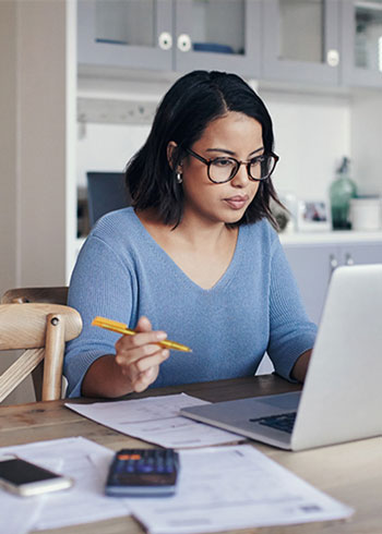 Woman sitting at the table while looking at a computer