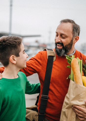 Father and son carrying groceries