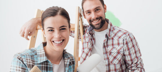 Man and woman posing with painting supplies